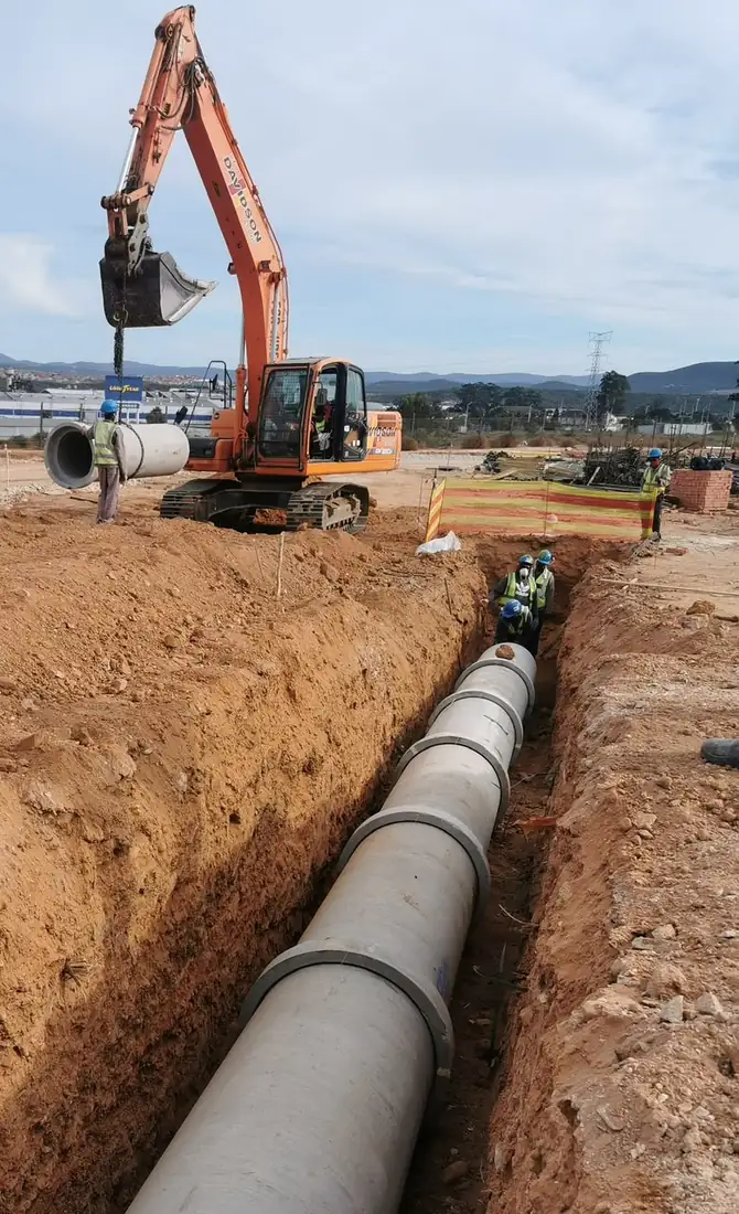Large concrete stormwater pipes being laid in a trench